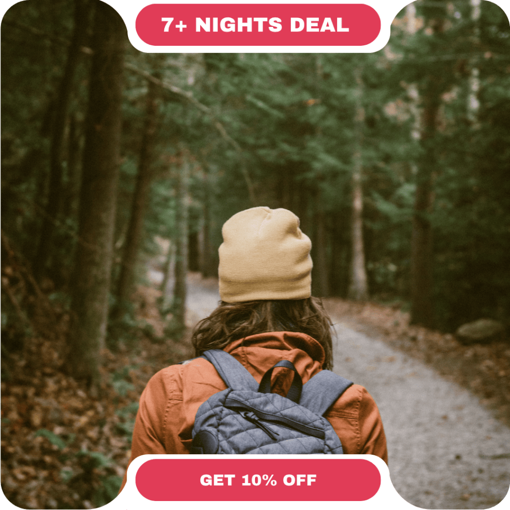 Person wearing a yellow beanie and backpack walks on a forest path, with text “7+ NIGHTS DEAL” and “GET 10% OFF” above—perfect for those seeking vacation rentals in Whistler.